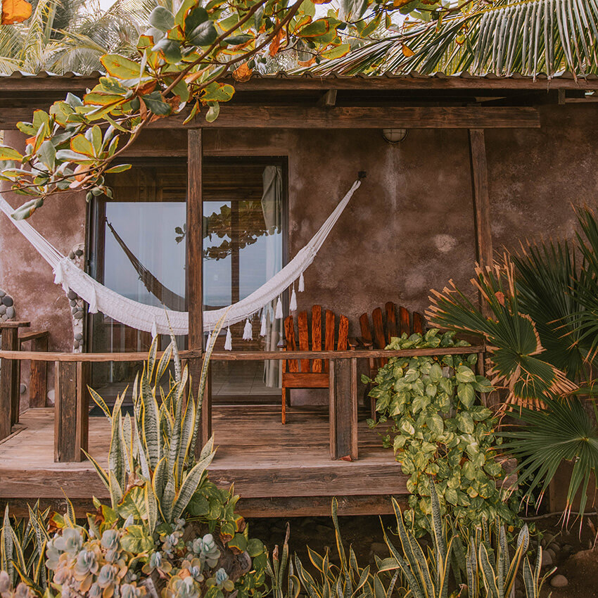 Charming porch with outdoor seating and hammock for the Private Jungle Bungalow at the women's Phoenix Retreat in El Salvador